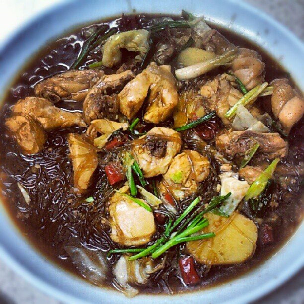 A close-up serving of jjimdak showing glass noodles and chicken glazed in dark soy sauce