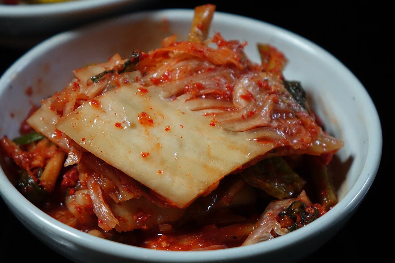 Finished red napa cabbage kimchi, whole leaves coated in chili seasoning