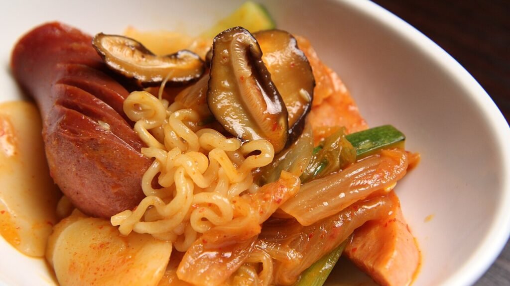 A bubbling pot of budae jjigae with Spam, sausage, and noodles