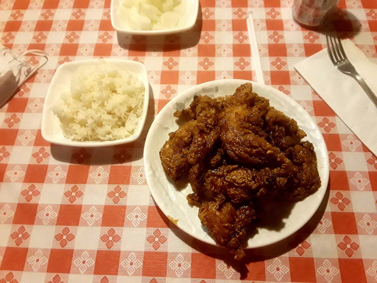 A plate piled with pieces of Korean fried chicken, golden and glazed