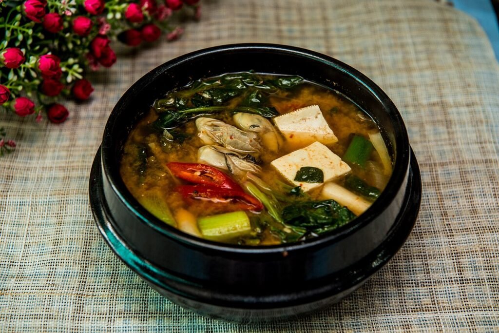 A bubbling pot of doenjang jjigae with tofu, zucchini, and potato