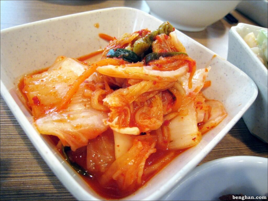Kimchi cut into bite-size pieces, coated in red seasoning, in a bowl