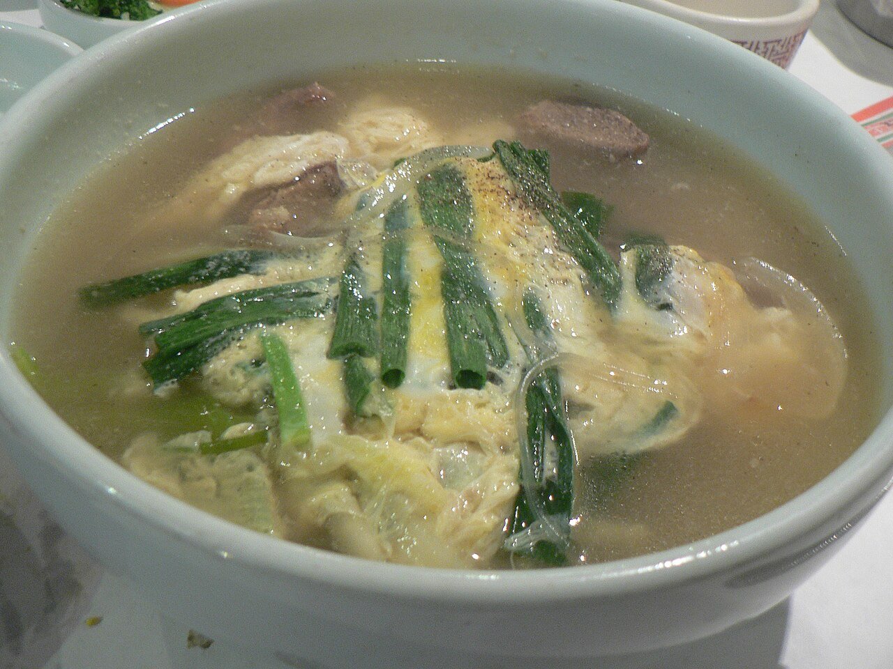 Galbitang served in a stone bowl with rice and side dishes on a restaurant table
