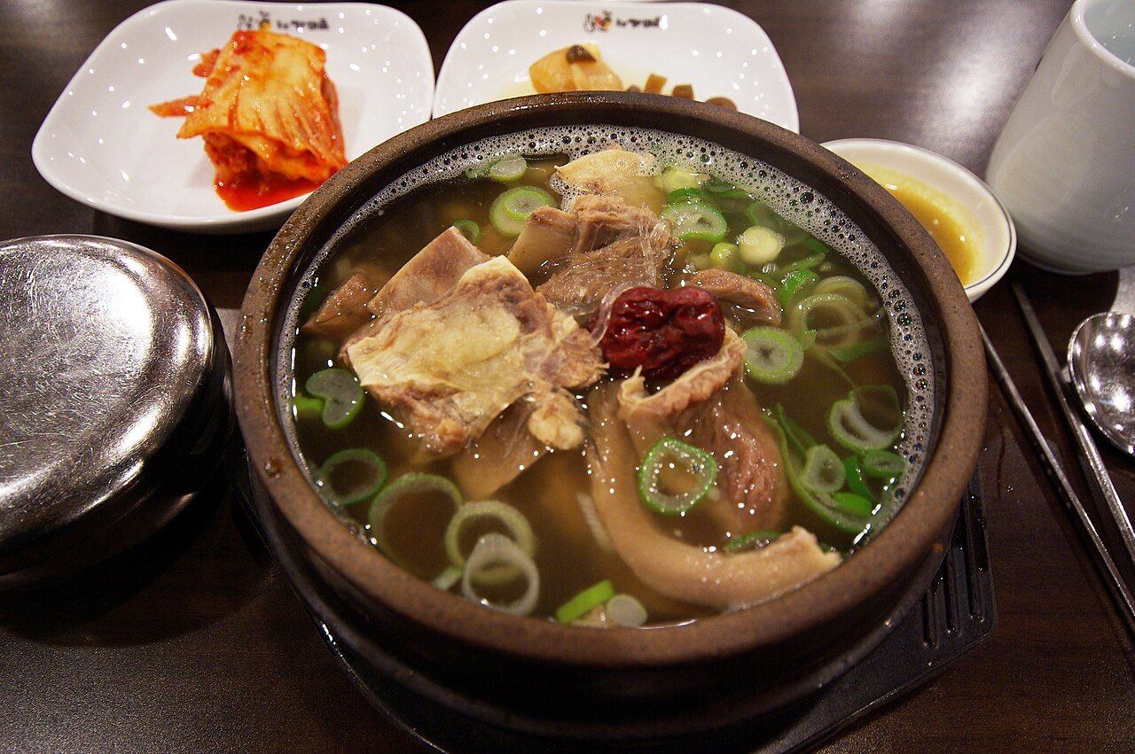 A close-up bowl of galbitang showing the short rib bone standing up in the clear broth