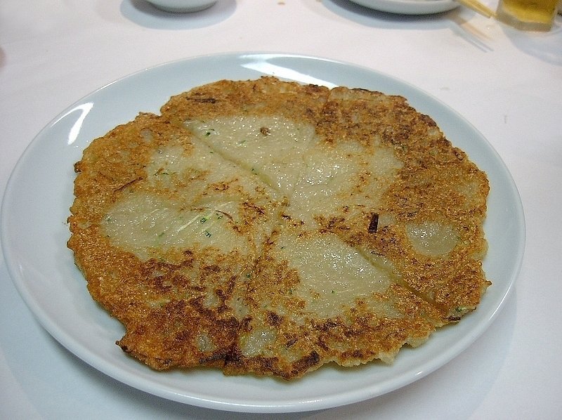 A golden Korean potato pancake, gamja jeon, resting on a plate