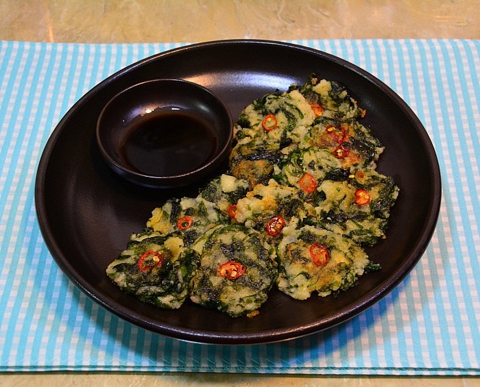 A potato pancake flecked with green laver, cut into wedges