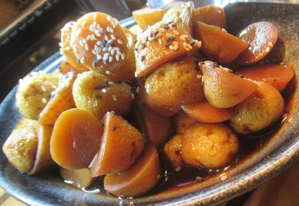 A bowl of glazed Korean braised potatoes, gamja jorim, in a dark soy sauce coating