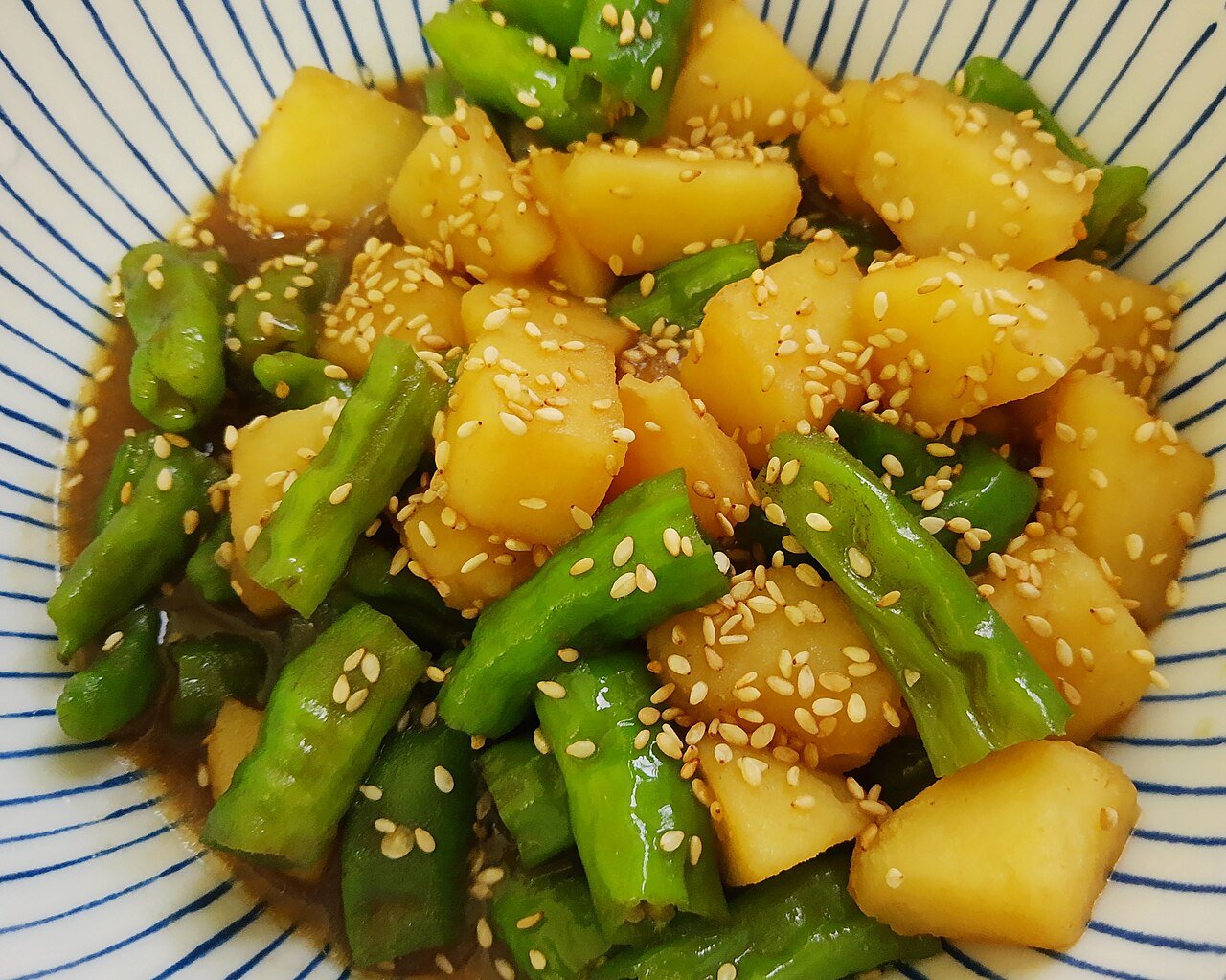Braised potatoes with shishito-style peppers in a home kitchen setting