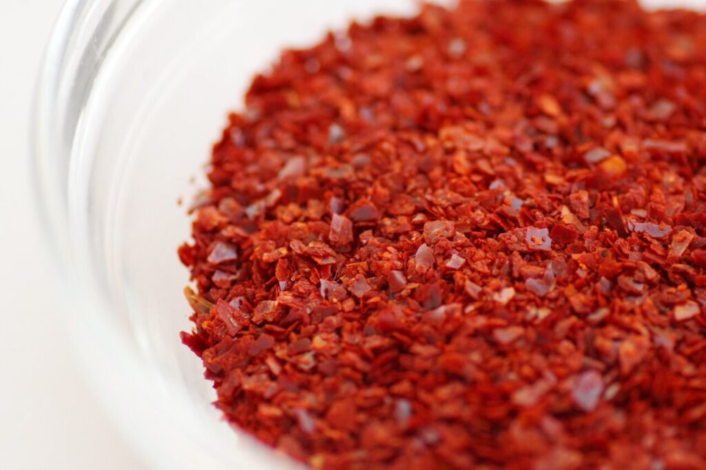 Coarse red Korean chili flakes, gochugaru, poured out in a heap