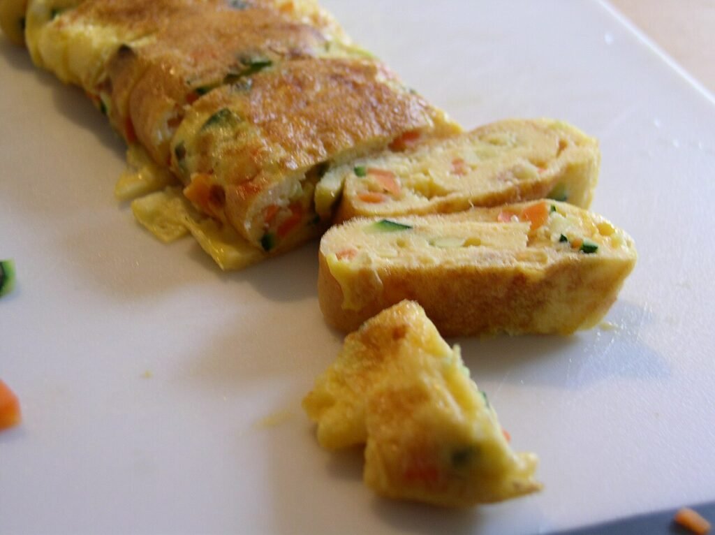 Sliced rounds of Korean rolled omelette, gyeranmari, arranged on a plate showing the spiral layers