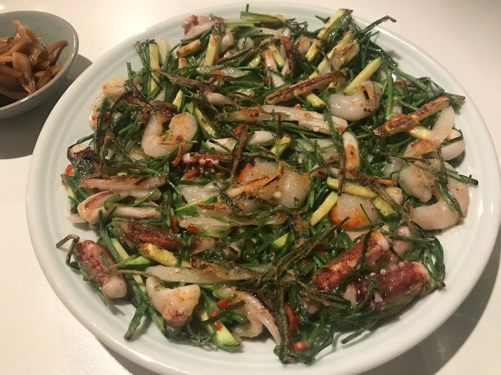 A golden-brown haemul pajeon scallion and seafood pancake on a plate
