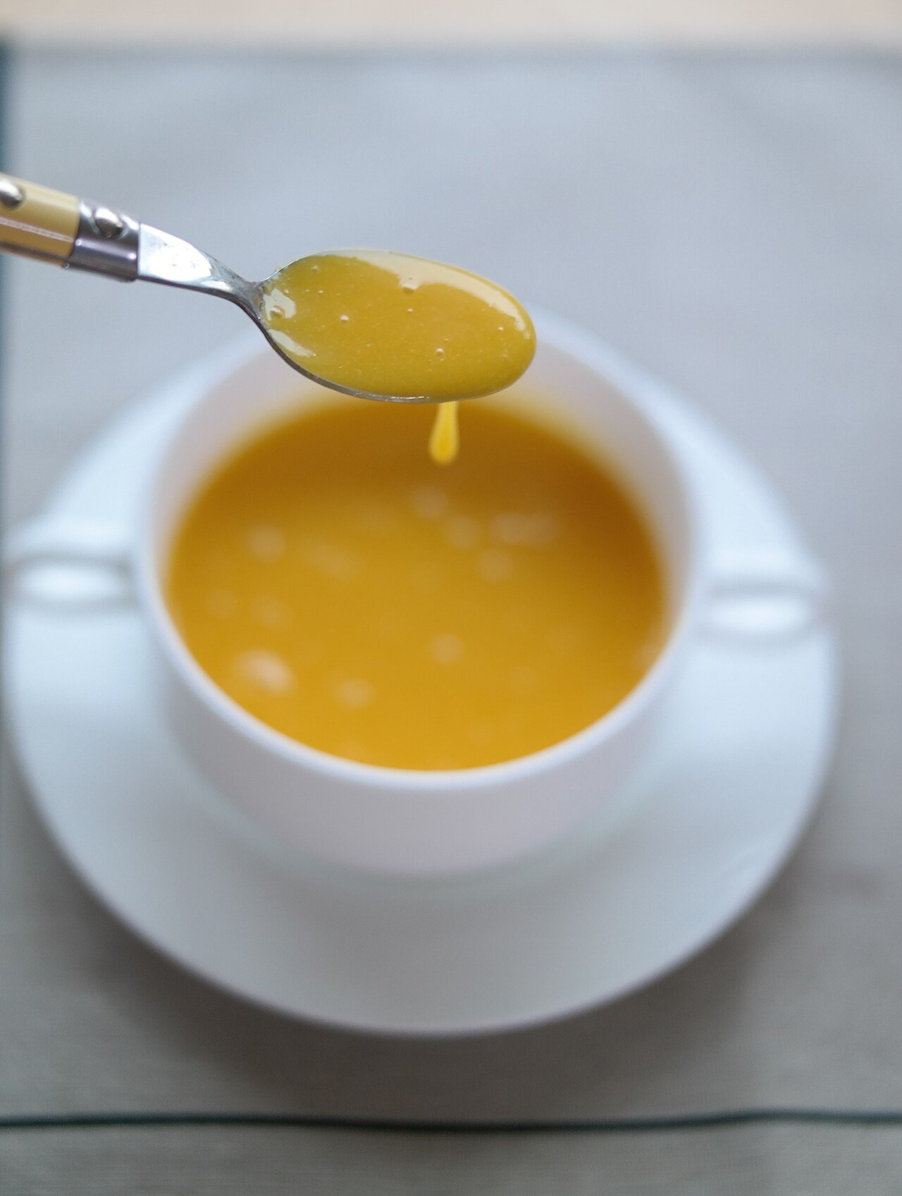 A close-up bowl of smooth orange kabocha pumpkin porridge