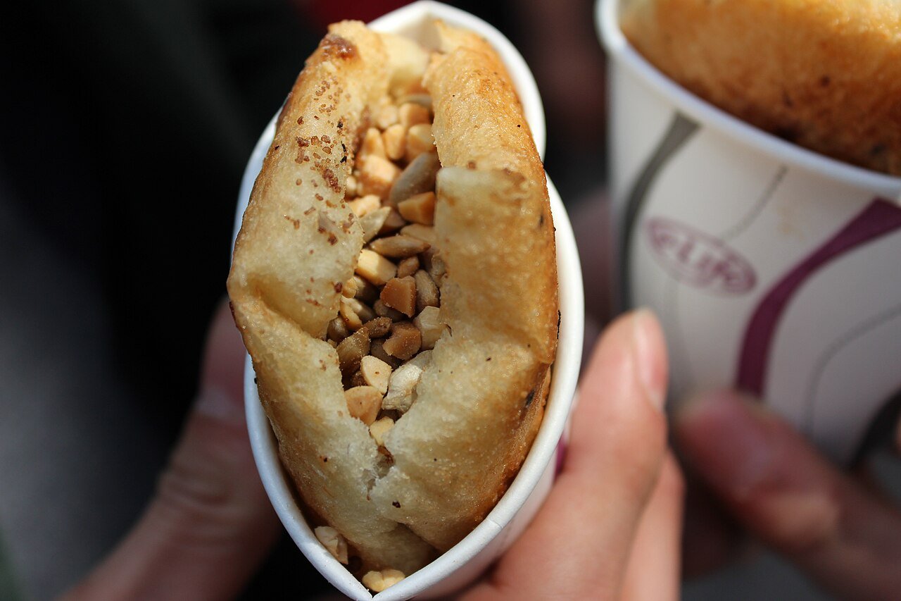 Ssiat-hotteok, a Korean sweet pancake opened along one edge and packed with sunflower and pumpkin seeds in brown sugar syrup.