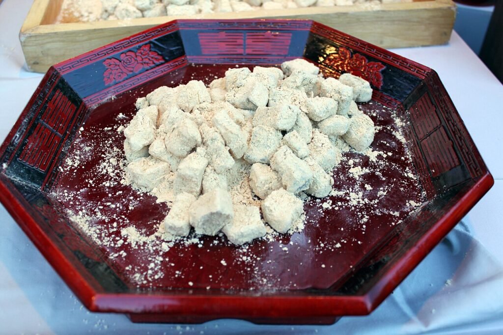 Small cubes of white injeolmi rice cake dusted heavily with beige roasted soybean powder, piled on a plate