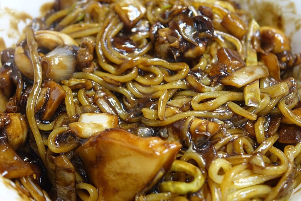 A bowl of jjajangmyeon with the black bean sauce tossed through the noodles