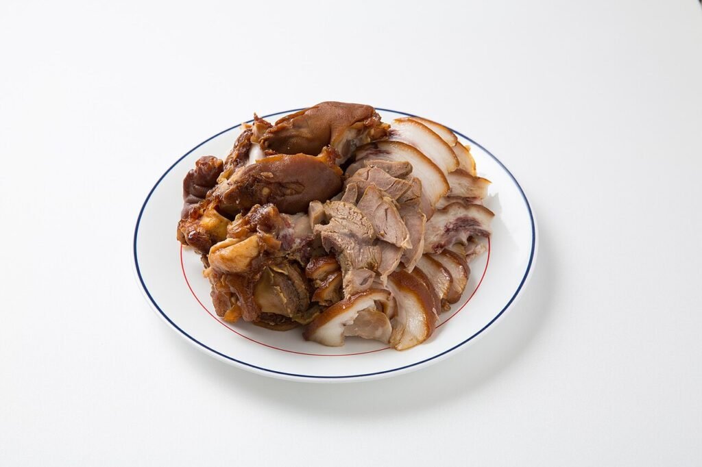Sliced braised pig's trotters arranged on a plate, skin dark and glossy from the soy braising liquid