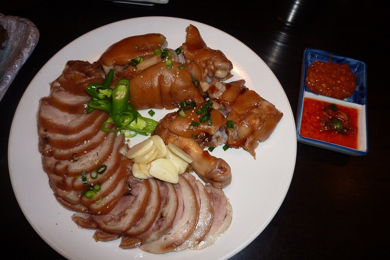 Jokbal served on a metal plate with the cross-section of skin, fat and meat visible