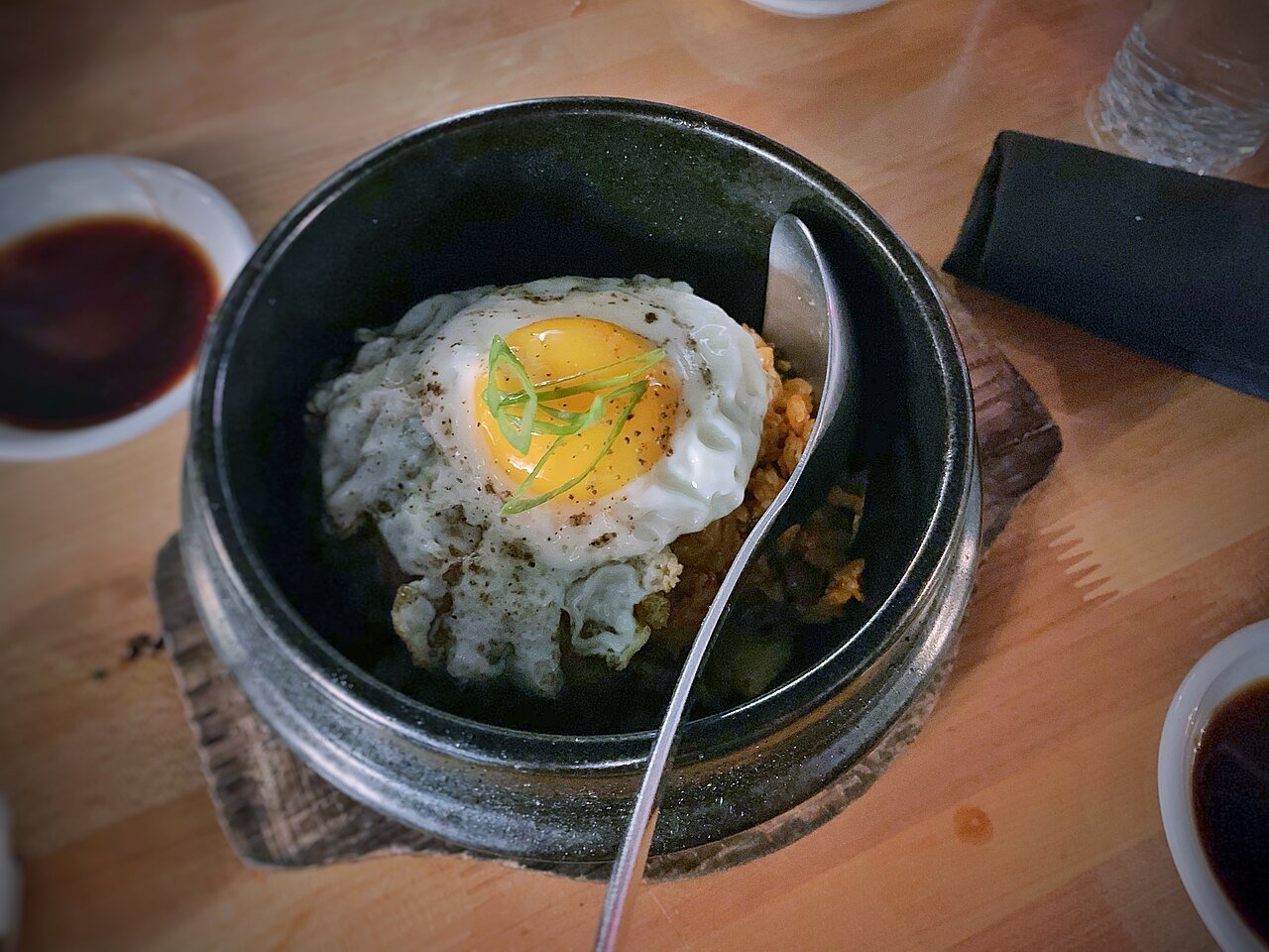 A bowl of kimchi fried rice topped with a fried egg with a runny yolk