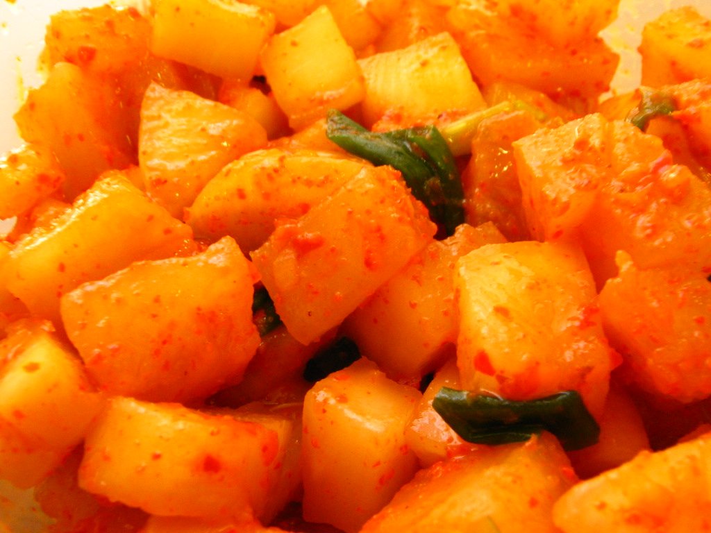 A bowl of cubed Korean radish kimchi, kkakdugi, coated in bright red chili seasoning