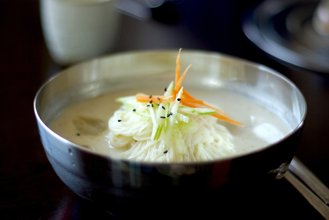 Kongguksu noodles in soy milk broth topped with julienned cucumber