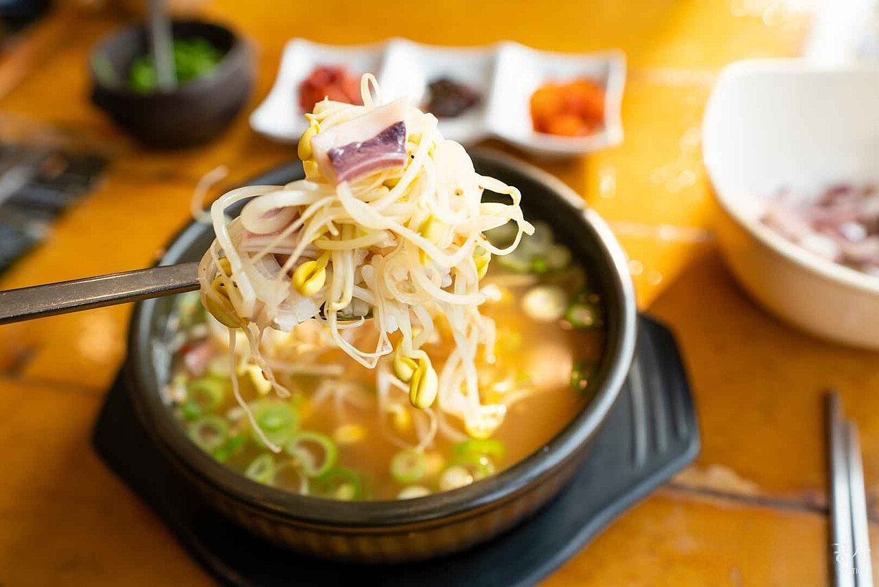 A bowl of kongnamul guk, clear Korean bean sprout soup, with scallion and sesame seeds