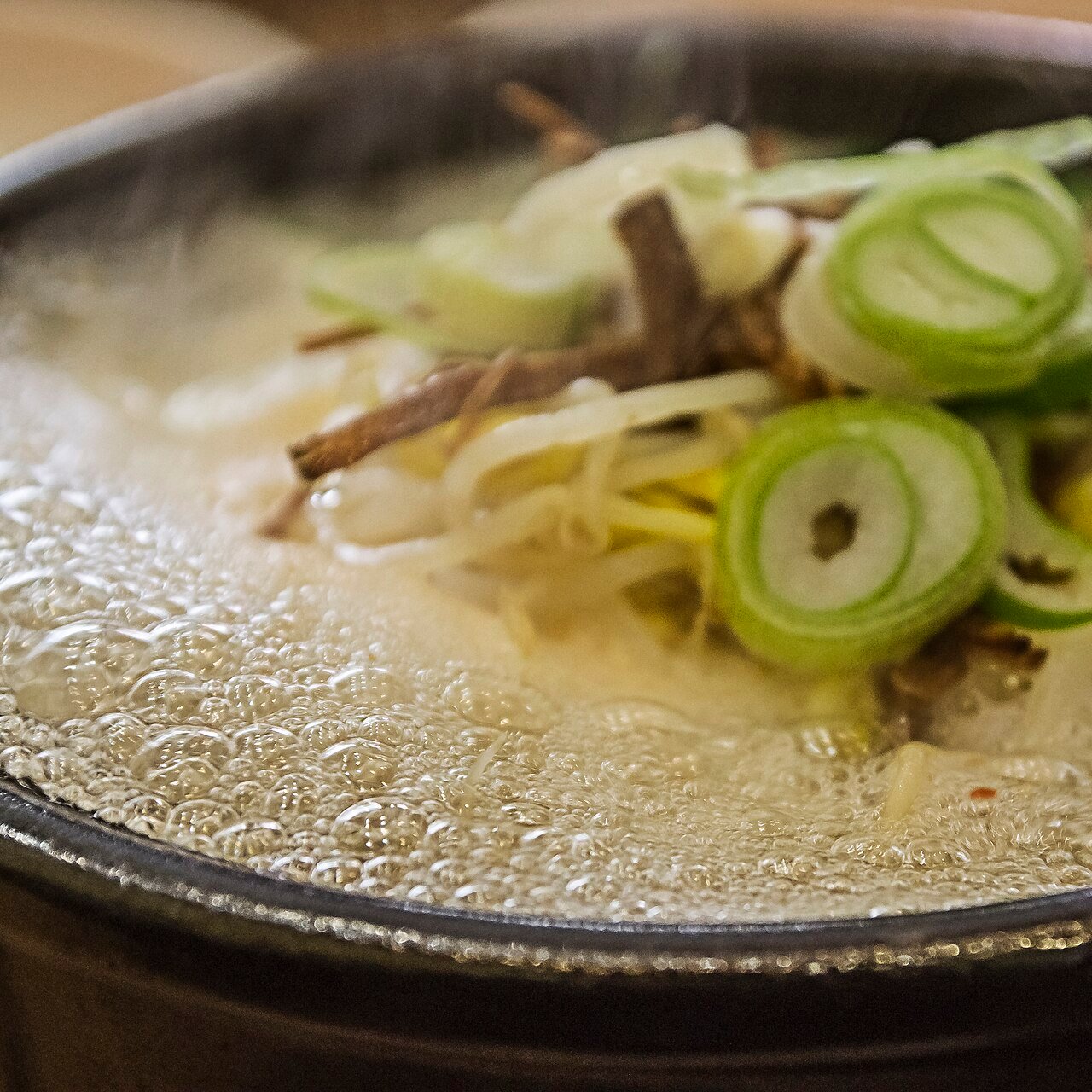 A close-up bowl of Korean bean sprout soup showing whole sprouts in a clear broth