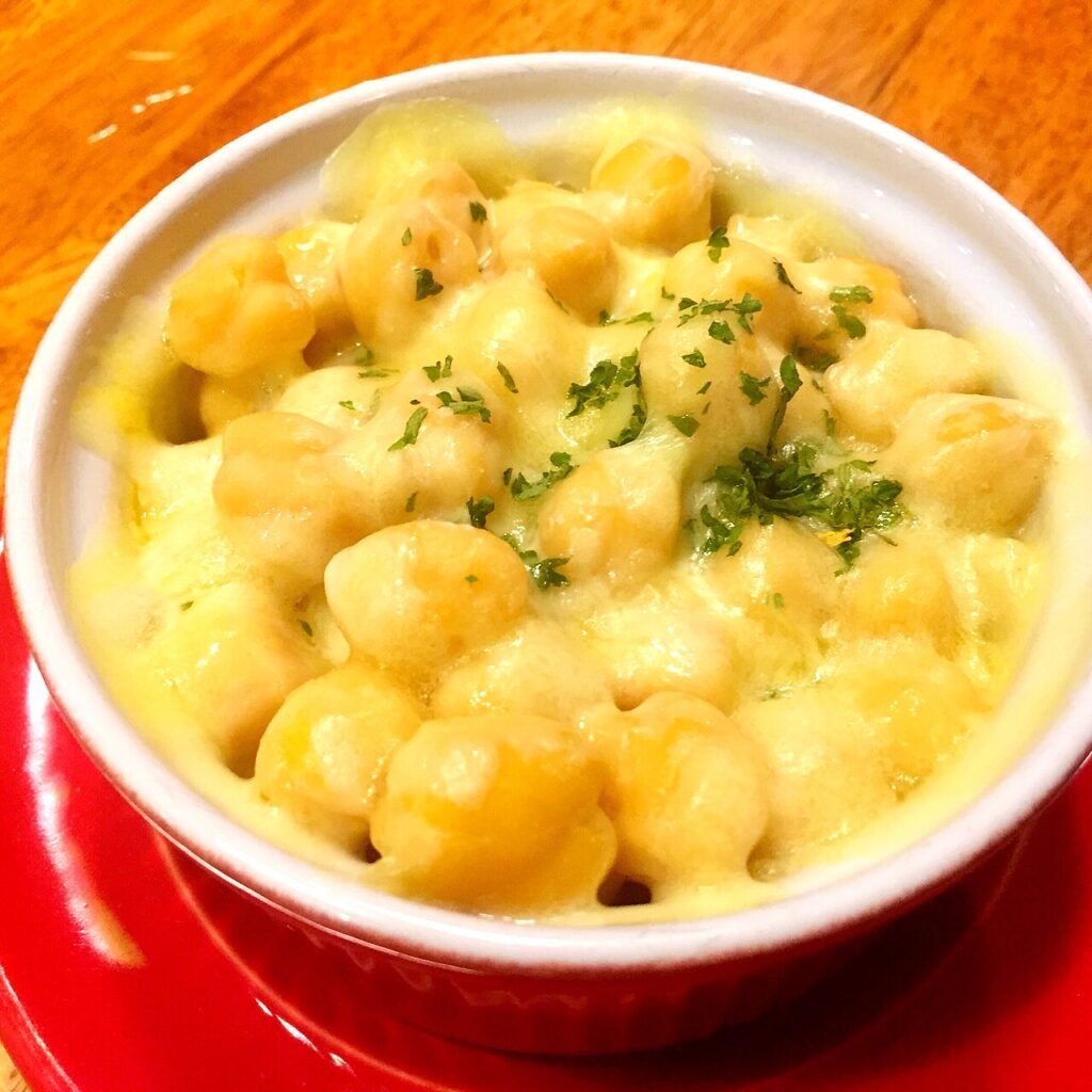 A skillet of Korean corn cheese, melted cheese pulled back to show buttery corn kernels underneath