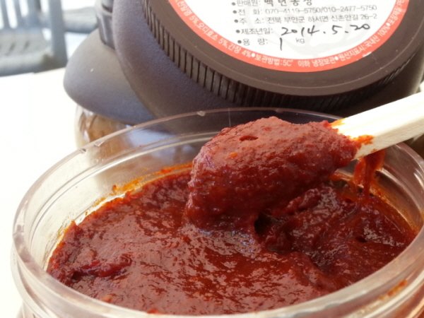 Thick red Korean chili paste, gochujang, in an open container