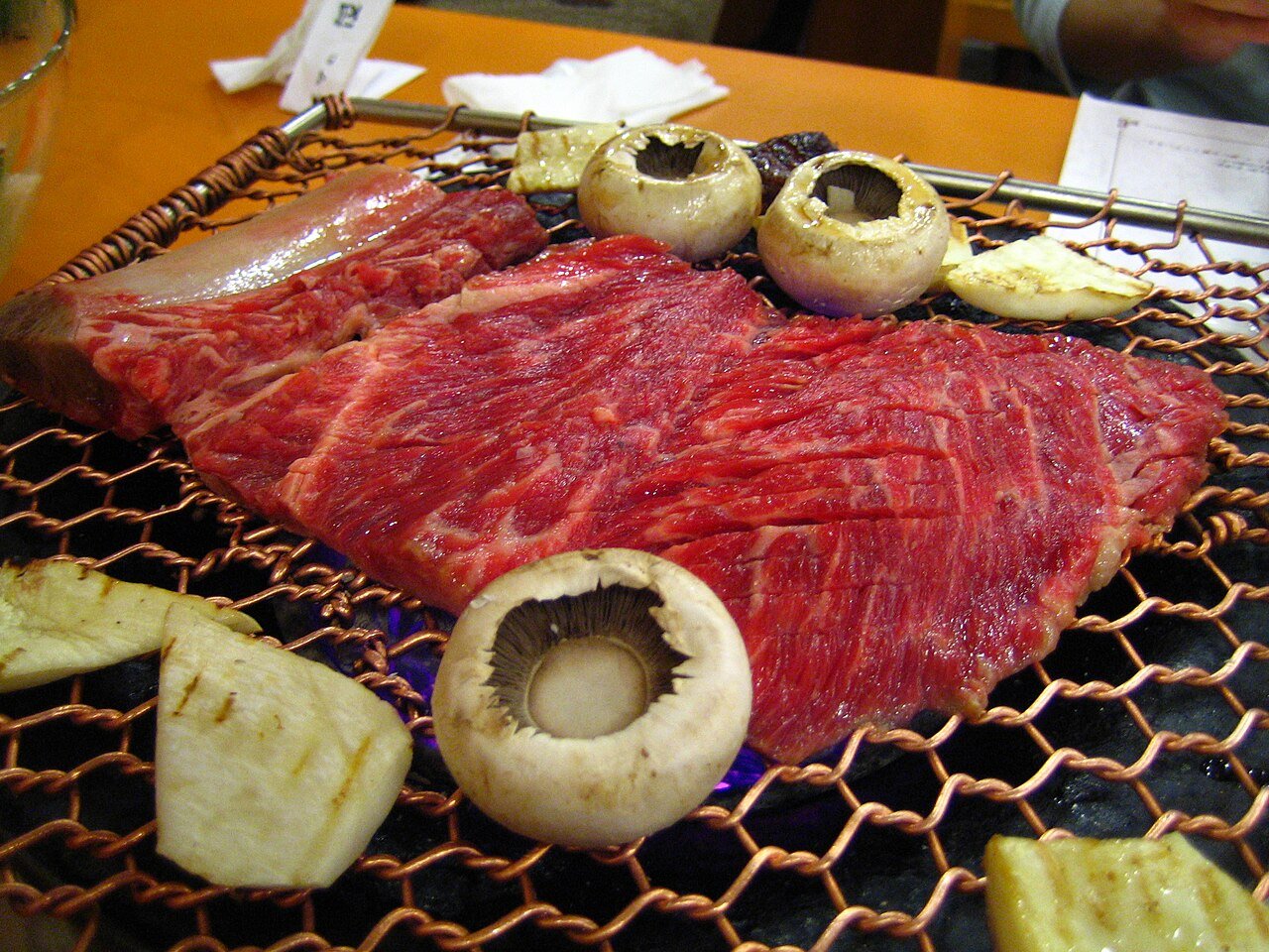 Marinated short ribs laid out on a grill plate, ready to cook