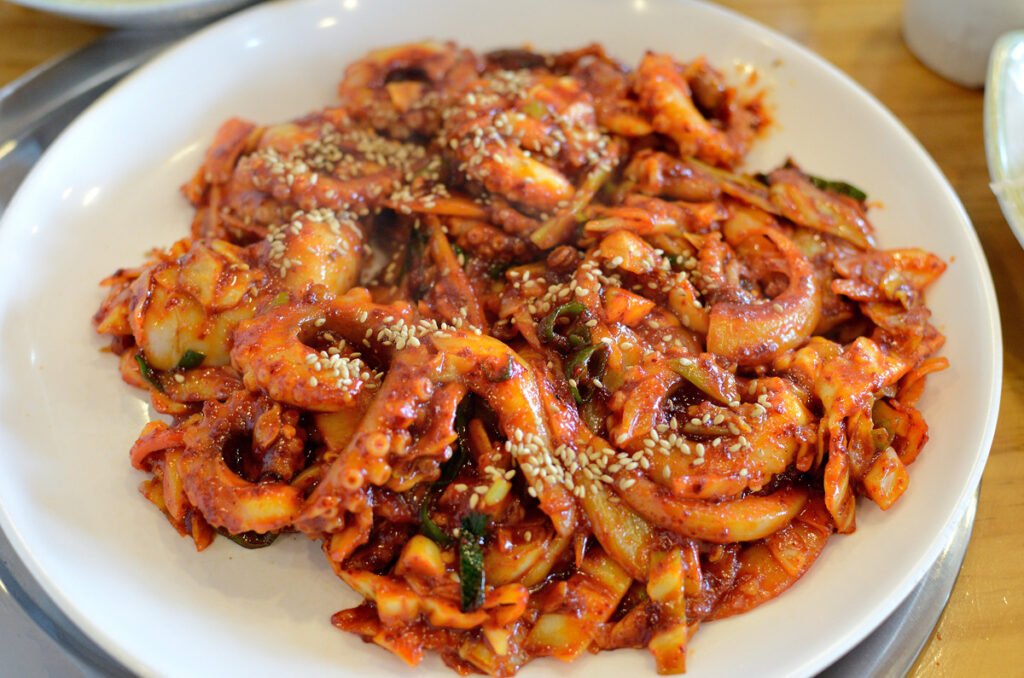 A plate of nakji bokkeum, spicy red stir-fried octopus with onions and scallions