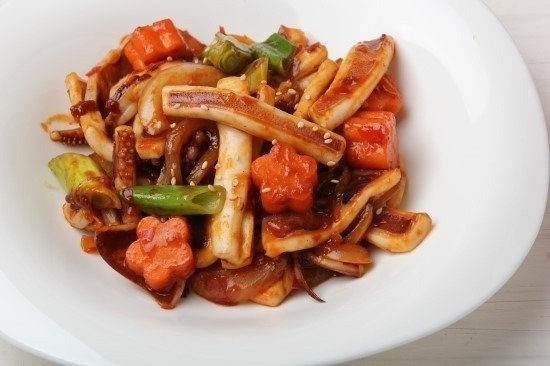 A plate of ojingeo bokkeum, spicy red stir-fried squid with vegetables