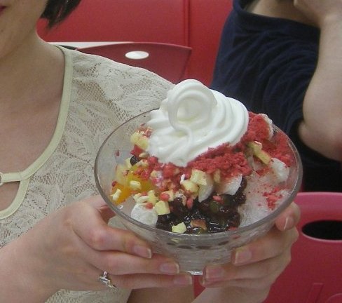 A bowl of patbingsu, Korean shaved ice, topped with sweet red beans, rice cake, and condensed milk