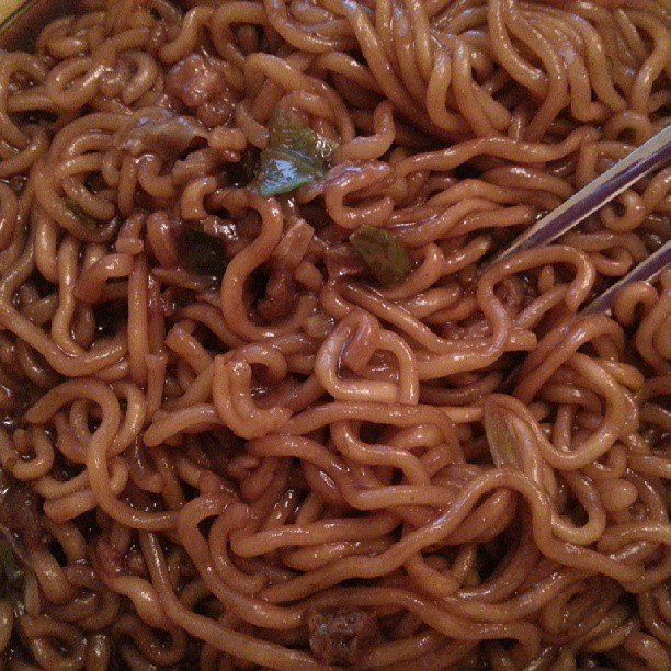 Chapaguri noodles served in a shallow bowl with chopsticks resting on the rim