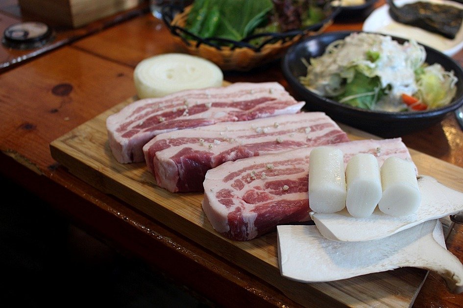 Raw thick-cut pork belly slices arranged and ready for the grill