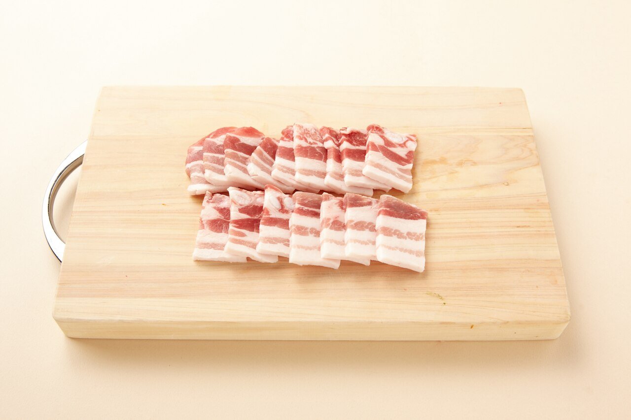 Samgyeopsal pork belly cooking on a tabletop grill