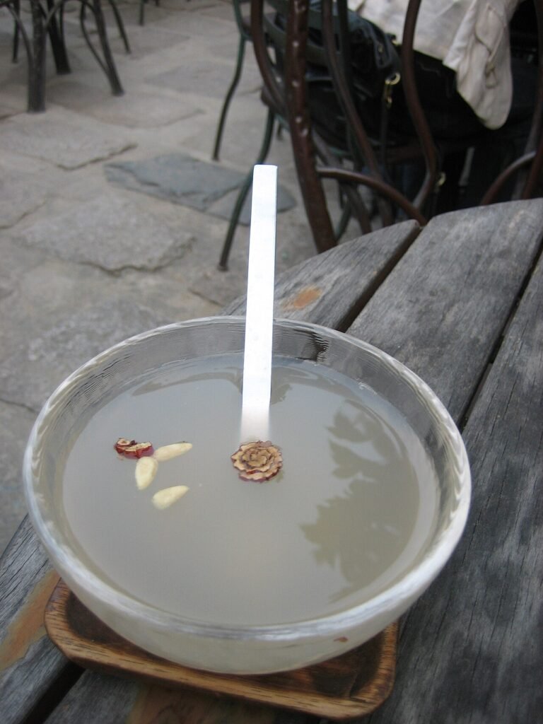 A bowl of sikhye, Korean sweet rice punch, with grains of rice floating on the surface