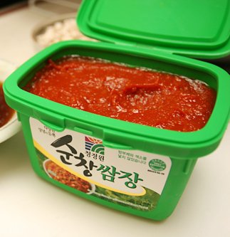 A close-up bowl of ssamjang, a thick reddish-brown Korean dipping paste