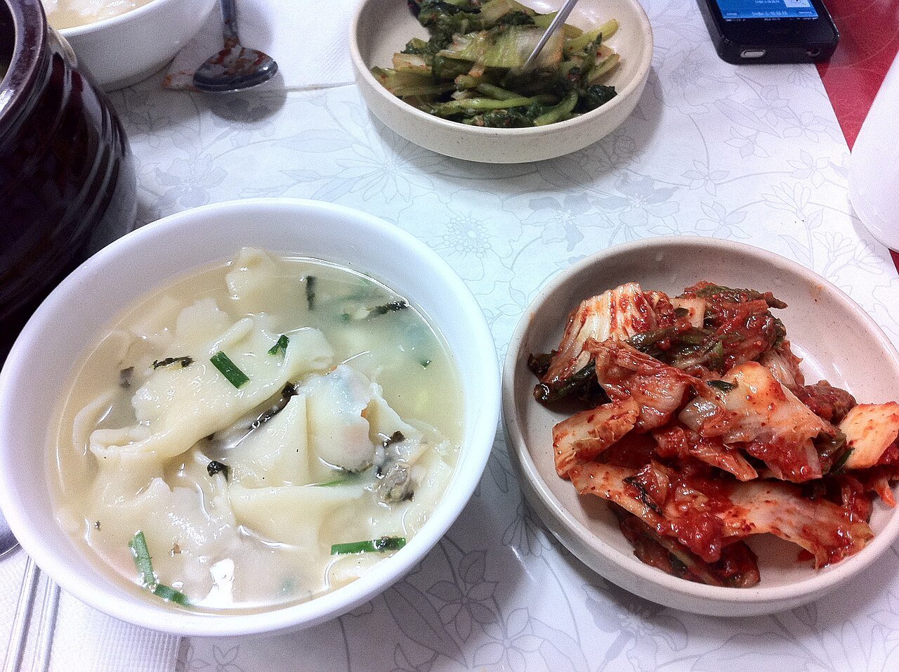 A bowl of sujebi served alongside a small dish of kimchi
