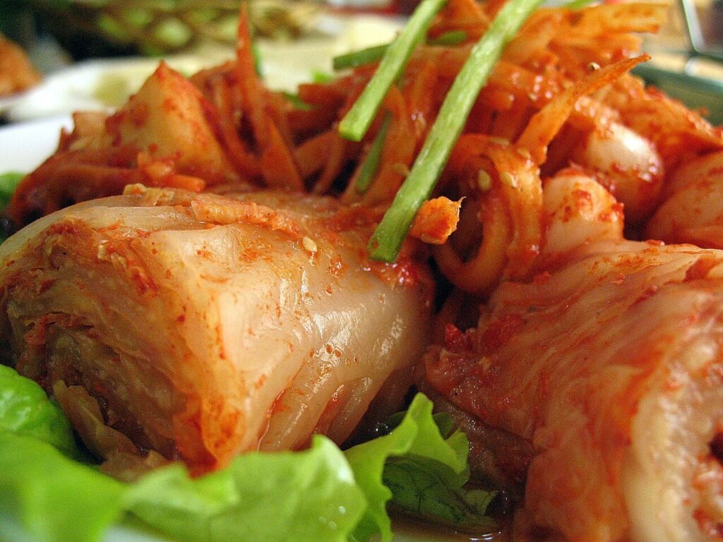 A bowl of finished napa cabbage kimchi, deep red and glossy, ready to serve