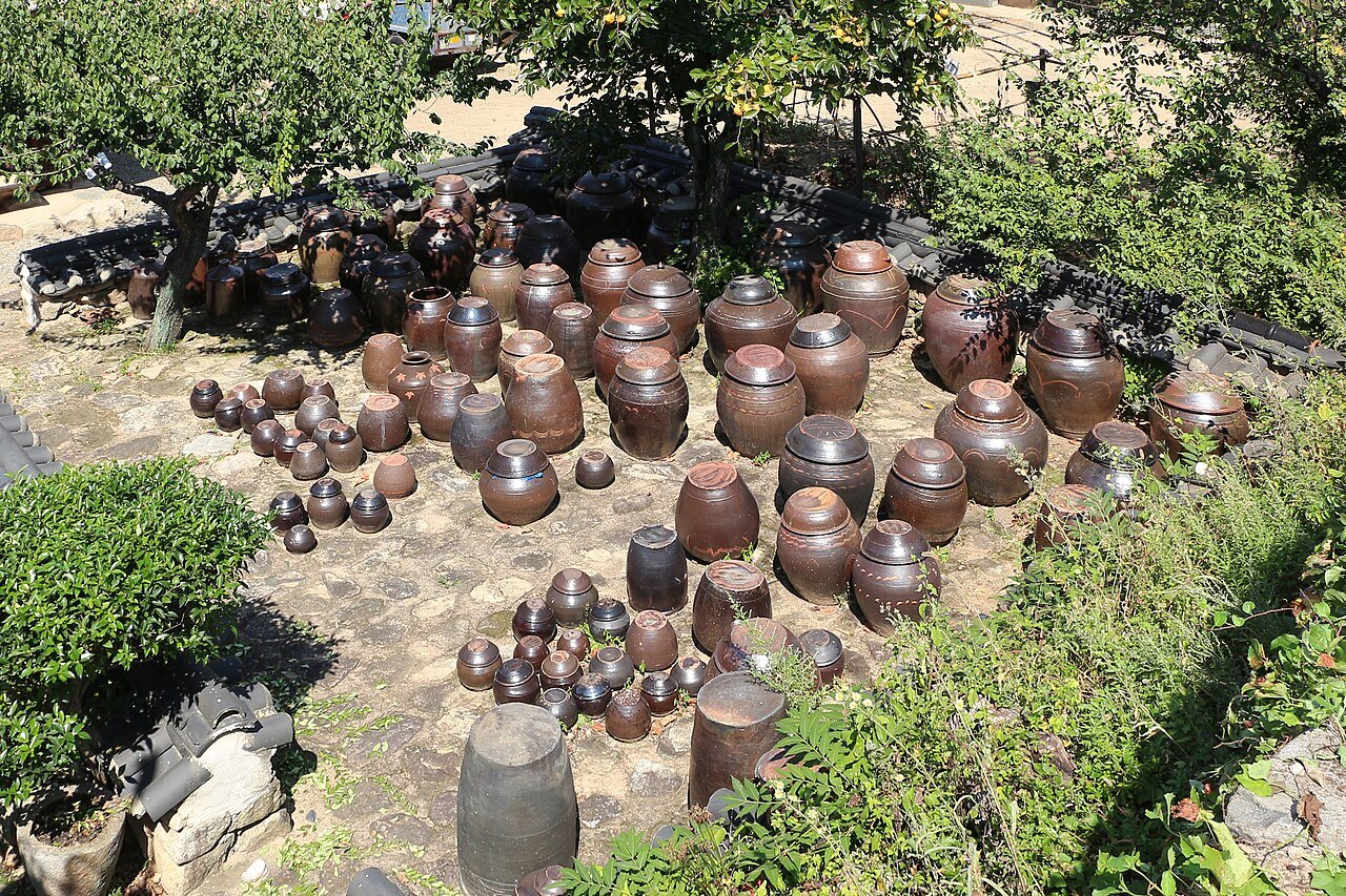 Rows of traditional Korean onggi clay fermentation jars on an outdoor platform