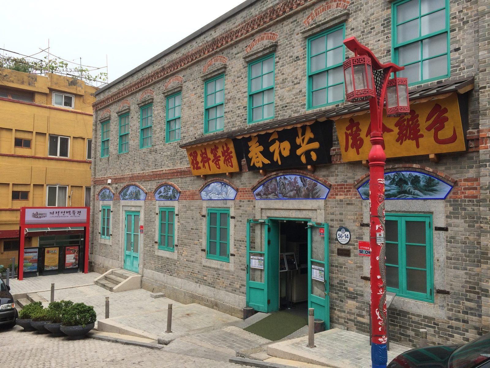 Brick two-story building with teal doors and gold Chinese signboard, home of the Jajangmyeon Museum in Incheon