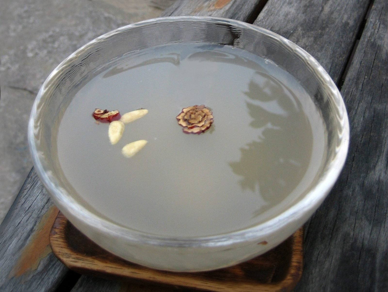 Cloudy sikhye in a bowl with pine nuts and jujube slivers floating on top